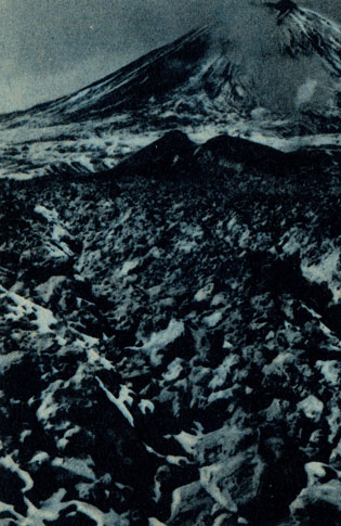 Рис. 16. Ключевской вулкан с паразитическим кратером Алахончич (на среднем плане). Из кратера вытек лоток базальтовой лавы, распавшийся на глыбы